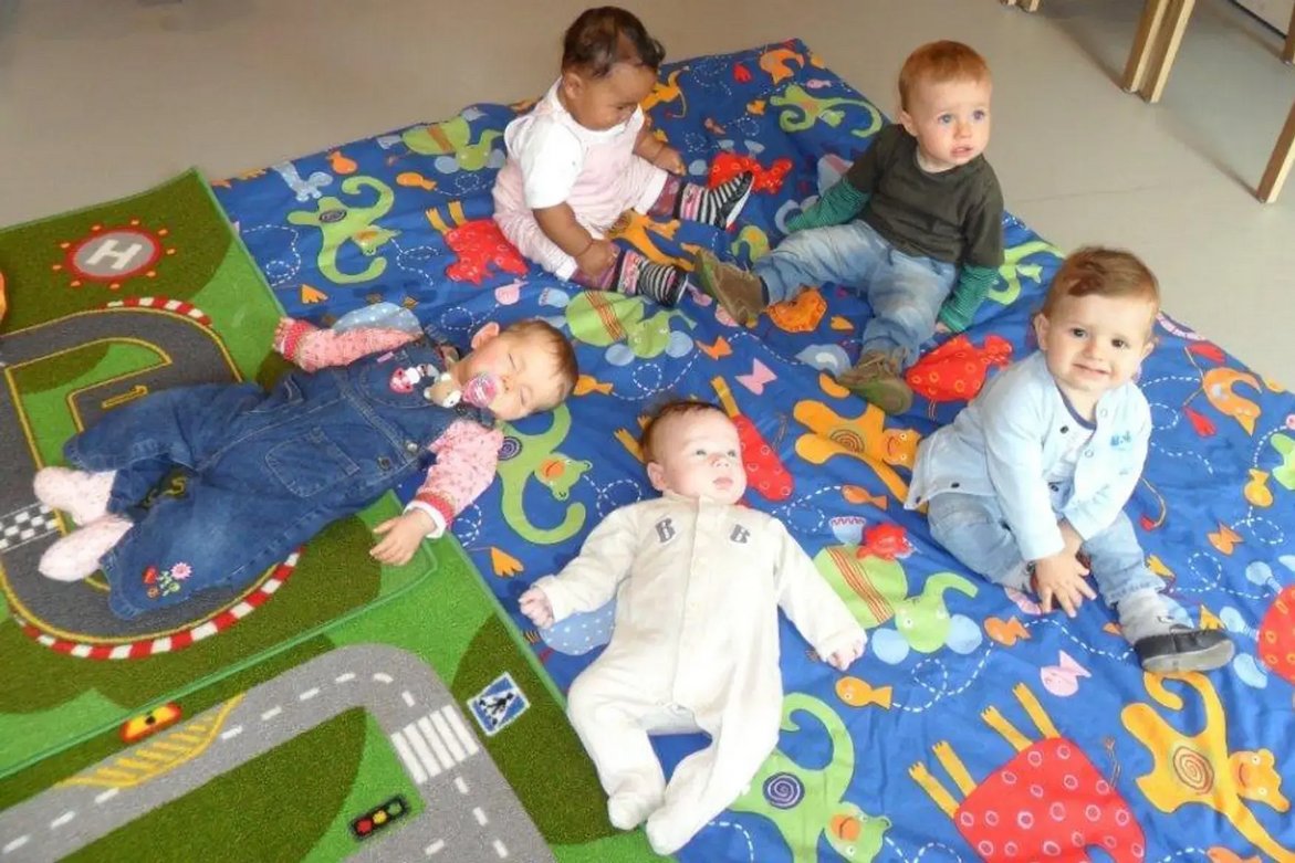 Kinder auf einem Spielteppich